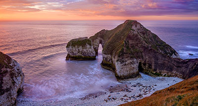 a cliff overlooking the Flamborough Sea Arch at dawn