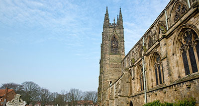 the south side and south tower of Bridlington Priory next to a graveyard